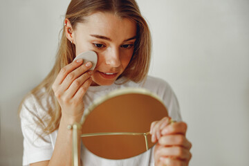 Poster - Woman wiping her face with cotton pad in the bathroom. Skin care concept