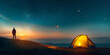Person camping with yellow tent on the  field hill at night with stars