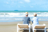 Fototapeta Kosmos - Asian Lifestyle senior couple hug and sitting on the beach happy in love romantic and relax time.  People tourism elderly family travel leisure and activity after retirement in vacations and summer