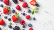A selection of assorted berries arranged artistically on a white surface, including strawberries, raspberries, and blueberries, showcasing their vibrant colors and juicy texture.