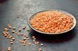 Red lentils in a bowl on a dark background close-up
