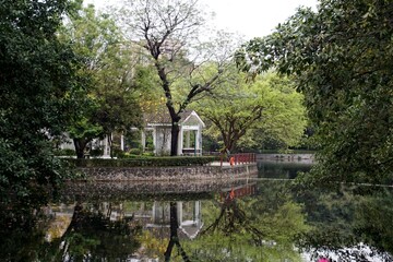 Sticker - a house is reflected on the water of a lake with a gazebo