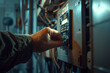A close-up shot of an electrician hand, flipping the switch of a circuit breaker in an apartment.
