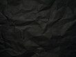 Black paper crumpled texture background 