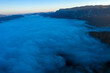 Flying above the clouds in dawn. Misty morning in the valley, aerial  view