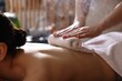 © New Africa - Spa therapy. Beautiful young woman lying on table during hot towel massage in salon, closeup