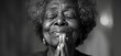 Old black christian woman praying to God. Black and white.