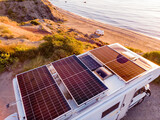 Fototapeta Do pokoju - Caravan with solar panels on roof camp on coast, Spain. Aerial view.