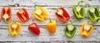 A variety of colorful peppers are displayed on a rectangular wooden table. These natural foods can be used as ingredients in a delicious vegetable dish or recipe