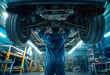 © Michael - A mechanic in a blue uniform stands under a car in a garage and checks the condition of the brakes on raised car