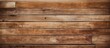 A close up of a rectangular wooden wall made of brown hardwood planks with a wood stain and varnish finish, creating a beautiful pattern resembling brick flooring