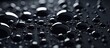 Multiple gleaming spheres are closely packed together on a dark black surface, creating a reflective and luminous effect