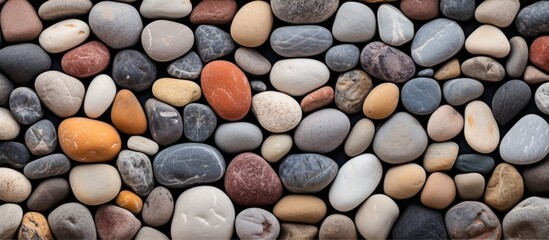 Sticker - An artistic arrangement of rocks, varying in size and color, on a black background. These natural materials can be used for building, cobblestone patterns, or even as decorative elements at a funeral