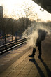 A smoking passenger on the platform at sunrise