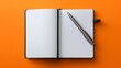 Crisp white notebook with silver pen on a vibrant orange backdrop invites creativity. A pristine notebook awaits the flow of ink