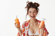 Joyful woman holding orange sunscreen bottles, tropical kimono against transparent background