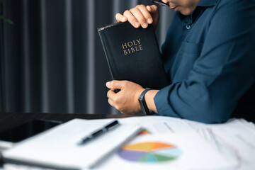 Businesswoman praying at work. Woman with hands clasped praying while sitting at desk in office. Contemplative prayer thinking in office. Hands folded in prayer gesture beg about something.