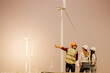 © Montri - Young man and woman maintenance engineer team. two engineer operate wind turbine. Engineer and worker discussing on a wind turbine farm. Wind Turbine. Maintenance Workers. renewable energies..