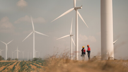 young man and woman maintenance engineer team. two engineer operate wind turbine. engineer and worke
