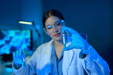 Wall Mural - A woman in a lab coat holding a test tube