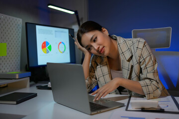 Poster - A woman is sitting at a desk with a laptop and a monitor
