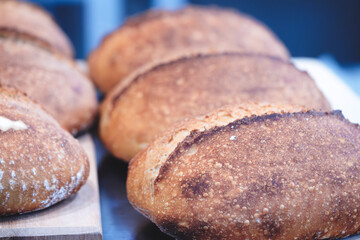 Poster - Fresh aromatic bread on a wooden table in a bread store or bakery. Nutrition concept