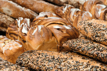 Poster - A variety of breads and pastries are displayed, including some with nuts and seeds. Concept of abundance and variety, with a focus on the different types of bread and pastries available