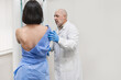 man doctor stands against the background of patient who is doing a mammogram. early diagnosis of breast cancer. mammography machine. routine regular examination for women over 35 years of age
