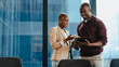 © Jacob Lund - Business colleagues reviewing project on tablet in modern office setting
