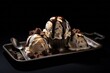 Refined ice cream on a metal tray against a dark background