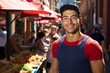 Portrait of a happy young man wearing a cap and apron in a busy outdoor market