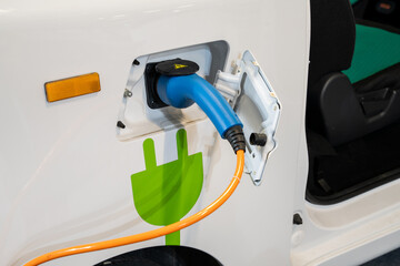 Sticker - Close up of electric car inlet with a connected charging cable.