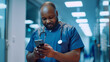 Black male nurse taking a break and checking his mobile phone