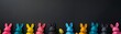 Black background with colorful Easter bunnies along the bottom border