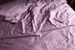 crumpled bed linen color dusty rose on the bed in the bedroom daylight