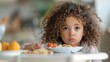 © AdriFerrer - Curly-haired girl with a contemplative look, not eating her food.