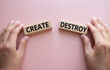 Create or Destroy symbol. Concept word Create or Destroy on wooden blocks. Businessman hand. Beautiful pink background. Business and Create or Destroy concept. Copy space