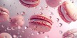 Pink macarons suspended in the air with water droplets around them, suggesting freshness or baking process.