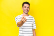 Young handsome man over isolated yellow background making money gesture