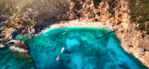 Canvas Print - Summer holiday background. Aerial view of seascape with stone coastline and small beach with crowd of people. Sea coast with blue, turquoise clear water. Islands of Sardinia in Italy