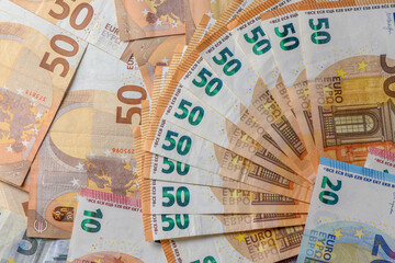 Fifty euro banknotes, arranged in a fan, against money background 2