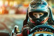 A young boy in a helmet driving a race car. Perfect for sports and racing themes