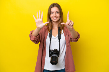 Wall Mural - Young photographer caucasian woman isolated on yellow background counting seven with fingers