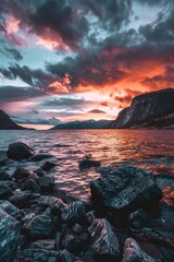 Poster - A serene sunset over a calm body of water with rocks in the foreground. Ideal for nature and landscape themed projects