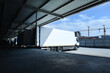 white trucks loading in front of the warehouse