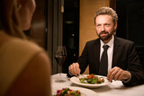 Fototapeta Łazienka - Elegant man is having dinner in a restaurant