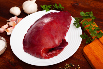 Wall Mural - Raw pork liver ready for cooking on cutting board closeup