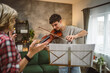 © Miljan Živković - Young man learn how to play violin under instruction mature professor