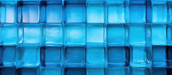 Poster - Close-up view of a solid wall constructed using transparent blue glass blocks, creating a unique and modern architectural feature