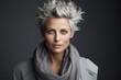 Portrait of a beautiful woman with short blonde hair and gray scarf.